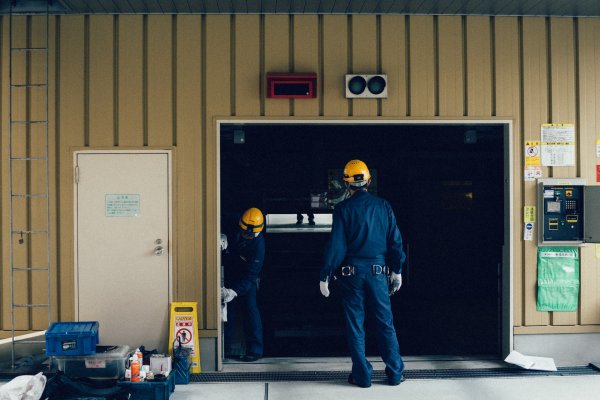 two people fixing a broken garage door